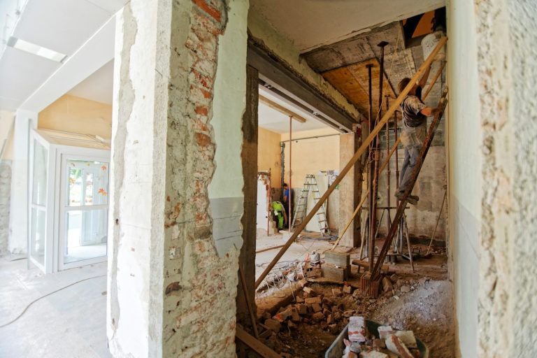 Interior of a building under renovation, with exposed walls and construction materials.